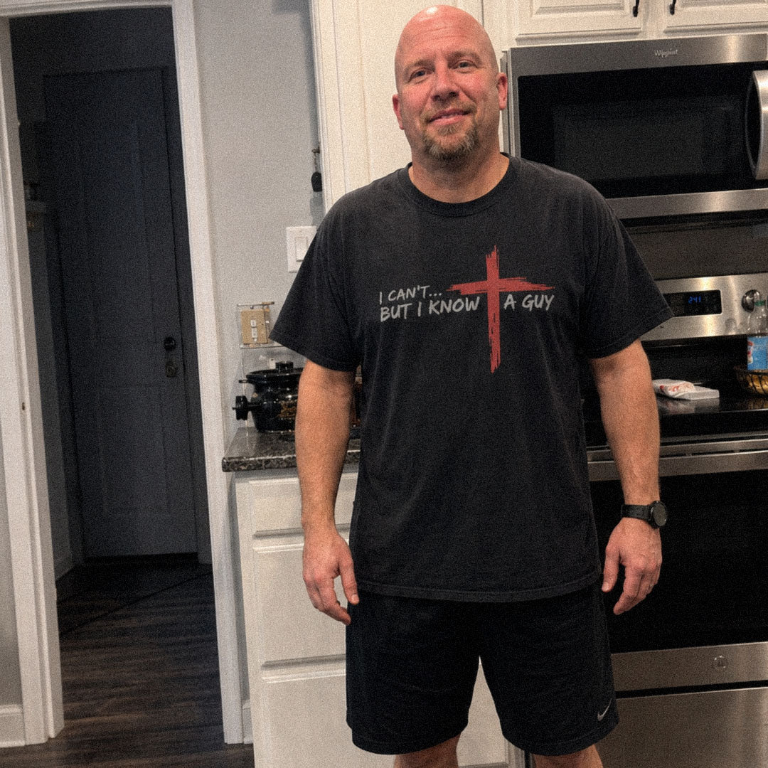 Man in kitchen wearing I Can't But I Know a Guy black Comfort Colors 1717® tee.