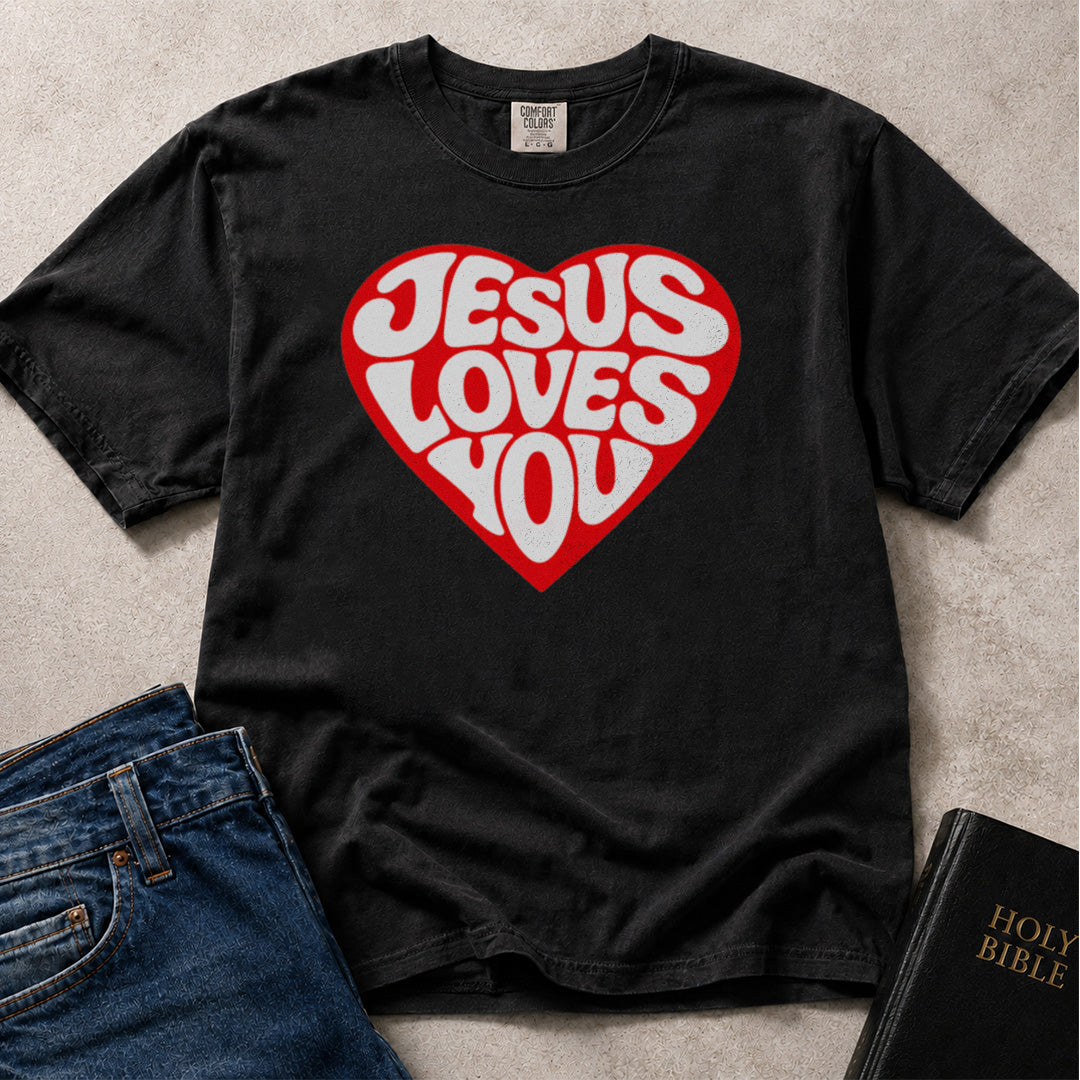 Black Comfort Colors® 1717 unisex tee featuring a bold red heart graphic with "Jesus Loves You" lettering in a retro typographic style.