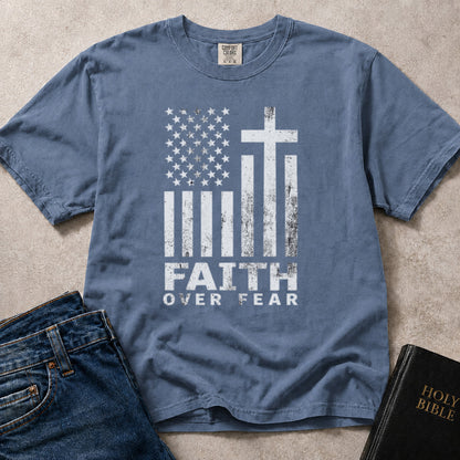 Blue Jean Comfort Colors 1717 patriotic Christian t-shirt with American flag and cross design, featuring 'Faith Over Fear' text.
