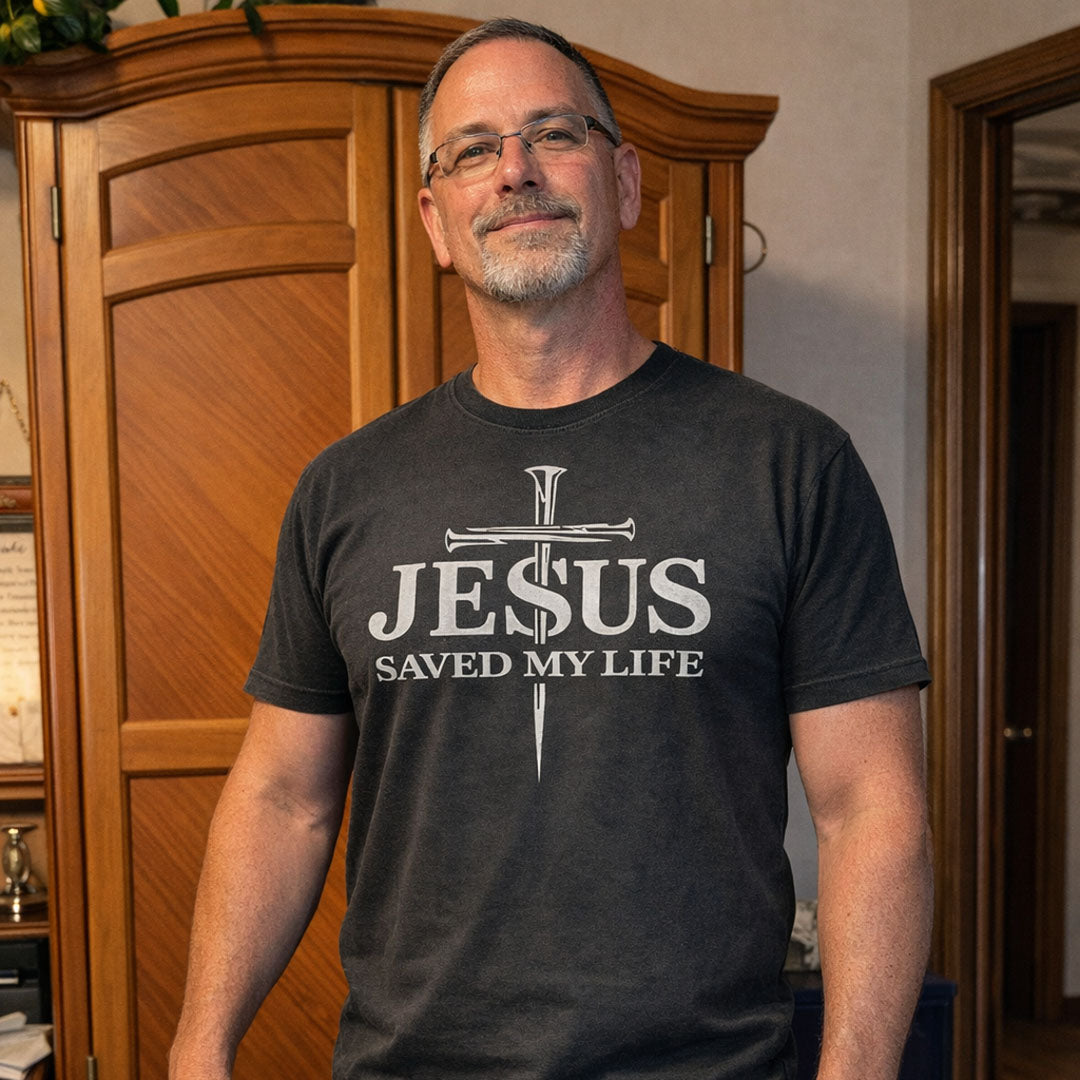 Man wearing charcoal Gray (Pepper) Comfort Colors® 1717 tshirt with bold Jesus Saved My Life faith inspired cross graphic.