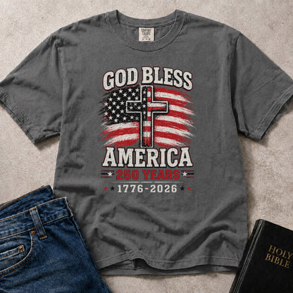 Charcoal Gray (Pepper) Comfort Colors® 1717 faith inspired tee reading God Bless America with patriotic lettering celebrating 250 years of American history.